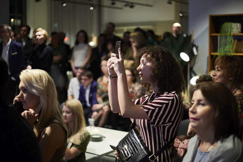 kobieta podczas robienia zdjęcia na 20-leciu BoConcept w Polsce na tle sali pełnej gości