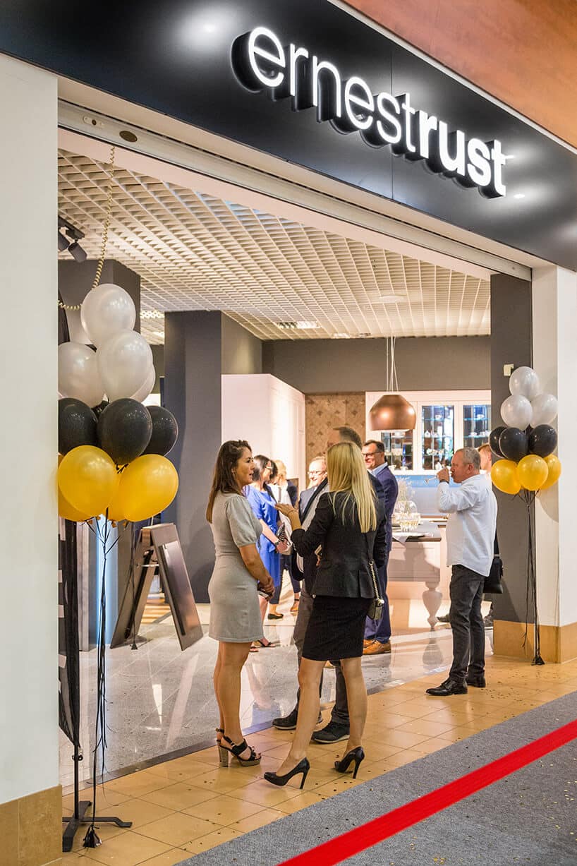 kilka osób przy wejści do showroomu ernestrust
