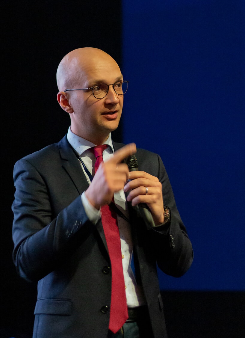 mężczyzna w garniturze i krawacie podczas wykłądu