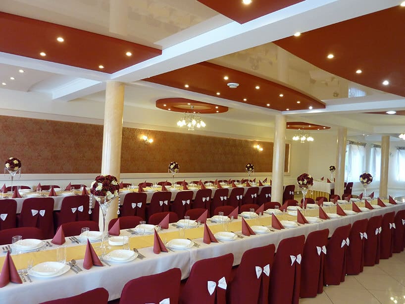 sala weselna z przygotowanymi dwoma rzędzami stołów
