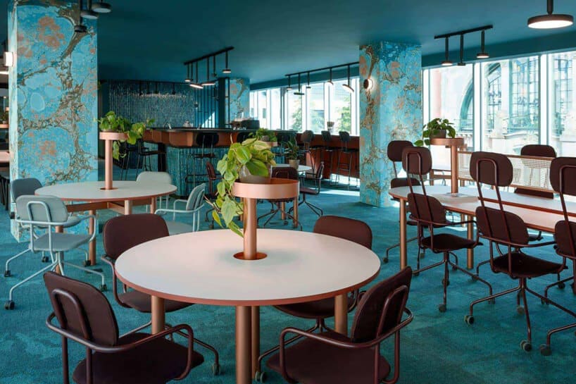 niebieskie wnętrze The Nest od Beza Projekt przestrzeń jadalni z okrągłymi stolikami i fotelami na kółkach