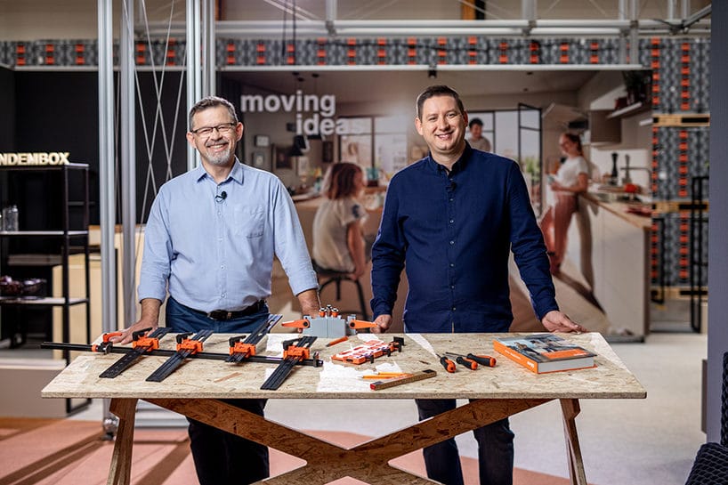 dwóch mężczyzn przy stole ze sklejki z prezentacją produktów Blum
