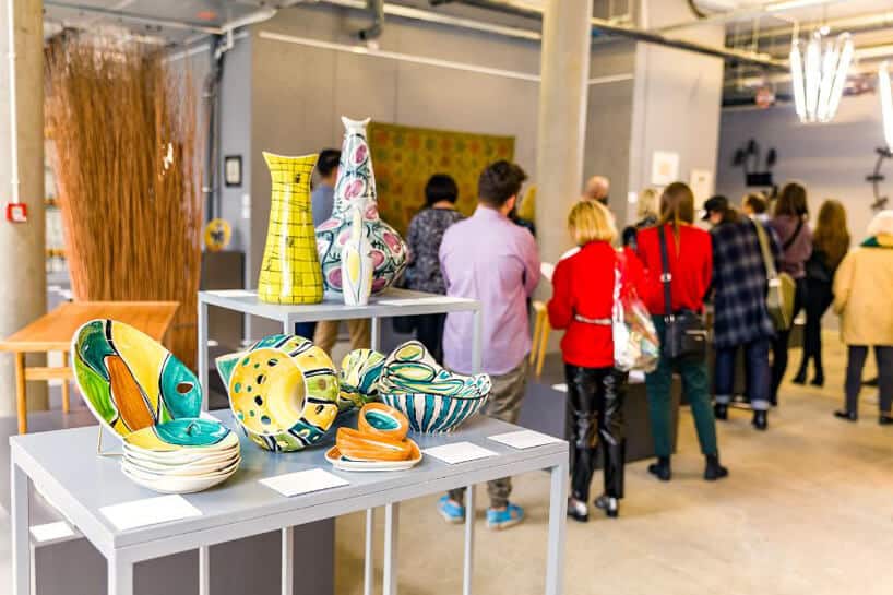 wzorzyste ceramiczne naczynia na tle odwiedzających ekspozycje