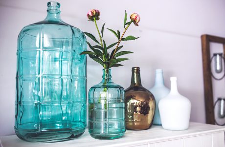 duży i mały wazon w niebieskim kolorze w kształcie butelki obok trzech wazonów z wąską szyjką w białym i złotym błyszczącym kolorze