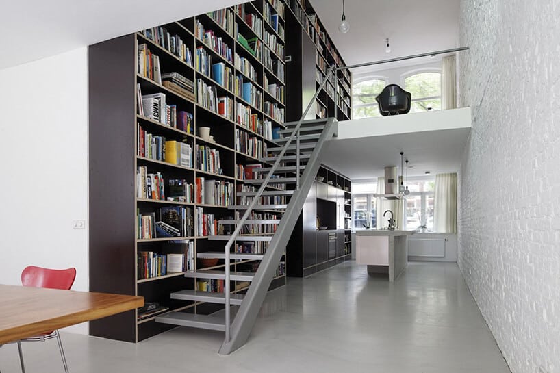 wysoka domowa biblioteka z szarymi metalowymi schodami na antresolę