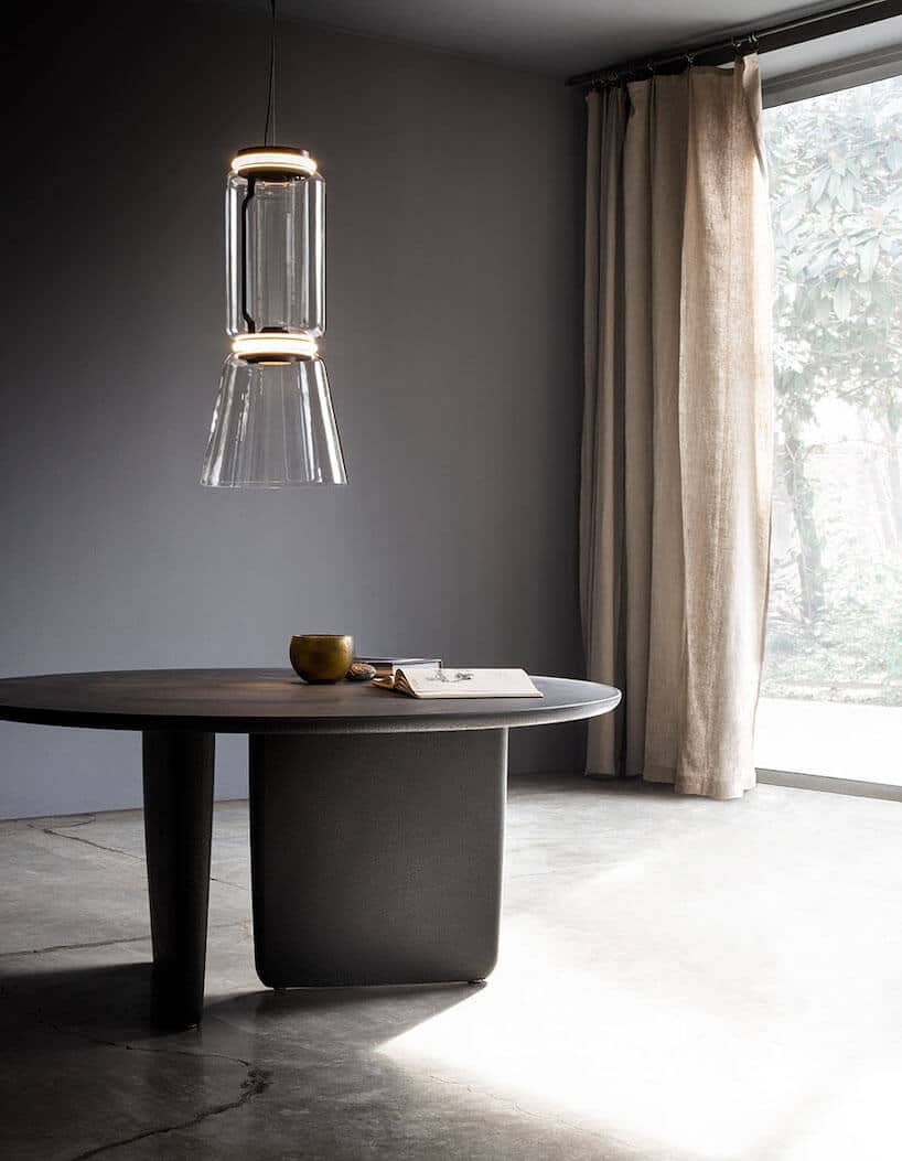 elegancka wisząca lampa Noctambule od Flos w długim szklanym kloszu z dwoma świecącymi krążkami