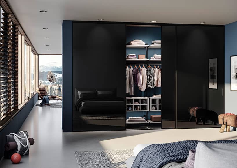 elegancka sypialnia z szafą z czarnymi szklanymi otwartymi drzwiami przesuwanymi