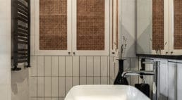 biała łazienka z kwadratową umywalką pod okrągłą lampą
