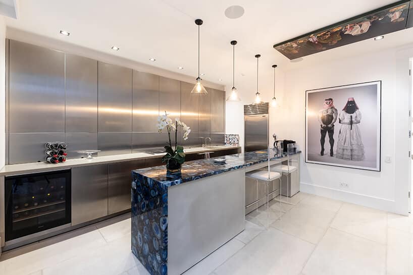 eklektyczne wnętrze apartamentu elegancka kuchnia z podłużną wyspą i frontami mebli kuchennych z metalu