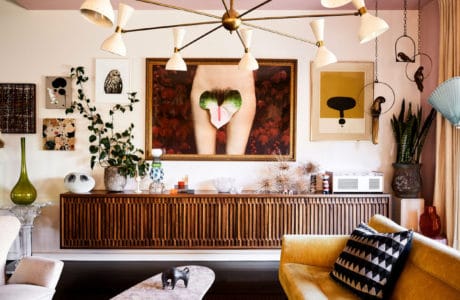 salon w stylu vintage z lekko pomarańczową kanapa dodatkami drewnianymi i obrazem