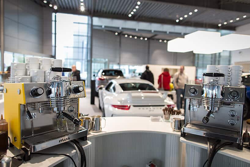 dwa ekspresy do kawy na białym blacie na tle białego porsche 911