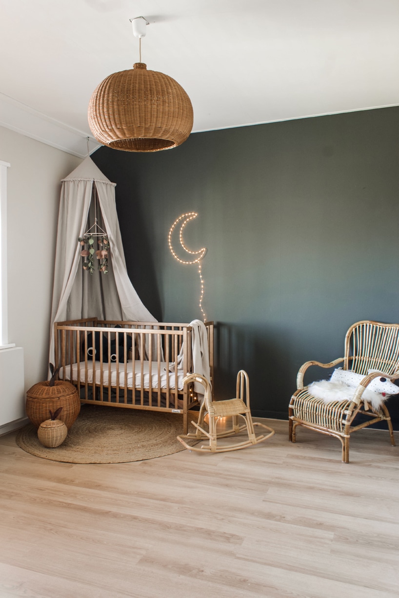 drewniane eleganckie łóżeczko od Woodies Safe Dreams w dużym pokoju z ciemnozieloną ścianą i świecącym księżycem