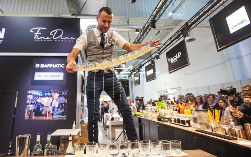 barman stojący na blacie prezentujący sztuczkę barmańską