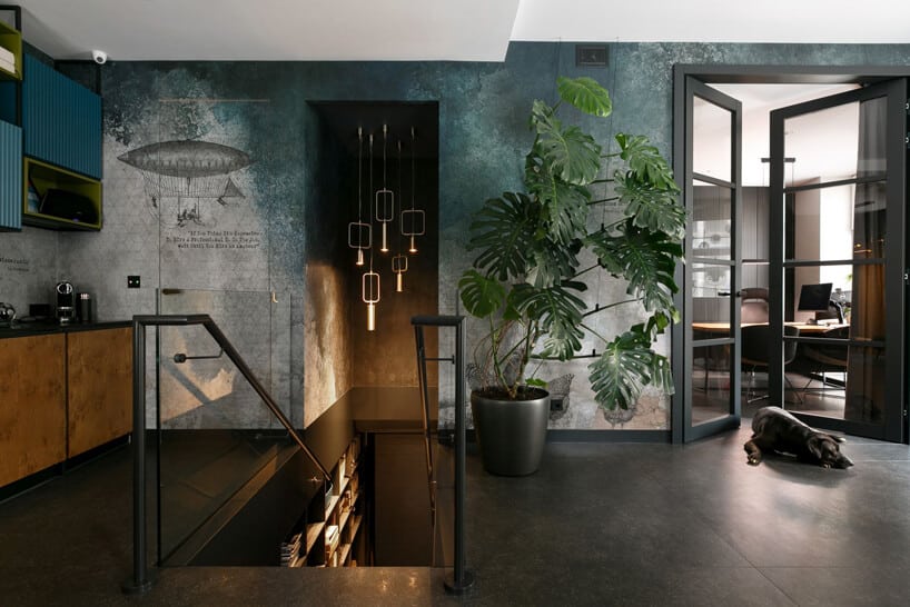 eleganckie ciemne wnętrze Siedziba MIKOŁAJSKAstudio z wąskimi ciemnymi schodami ze szklaną balustradą