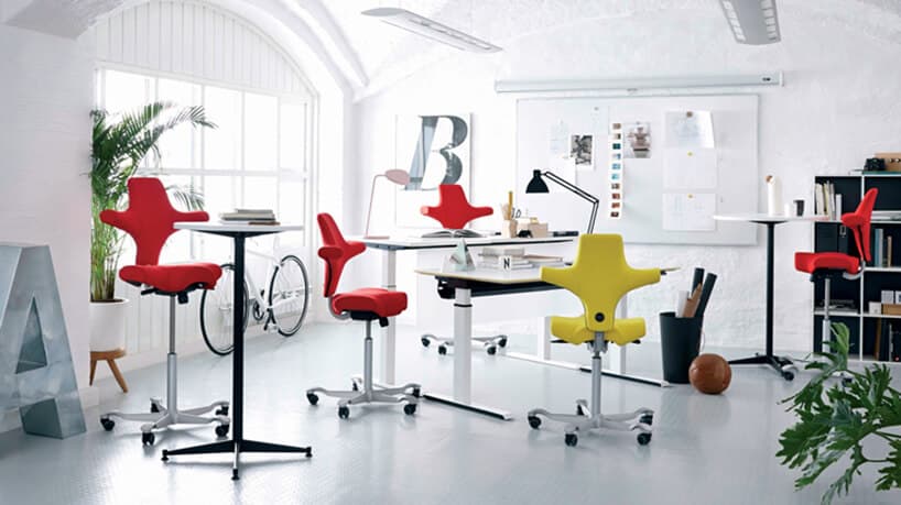 czerwone i żółte nowoczesne ergonomiczne krzesła biurowe Peter Opsvik w białym biurze