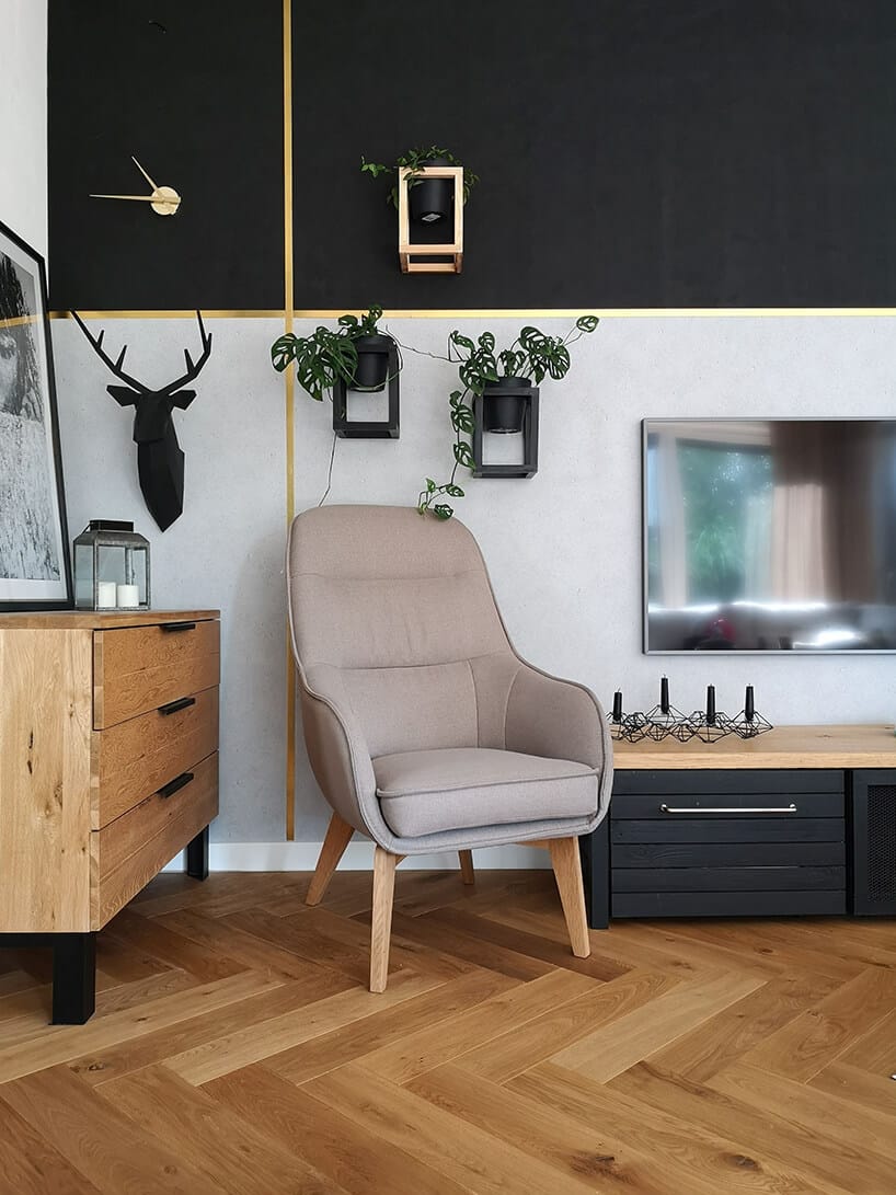 elegancki beżowy fotel Dot II Gala Collezione na drewnianych nogach w aranżacji salonu z szaro czarną ścianą ze złotymi liniami