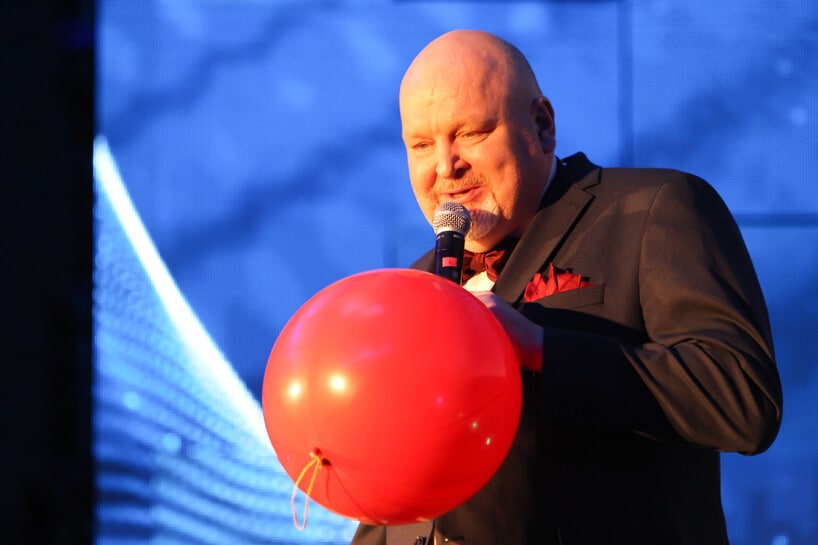 mężczyzna z mikrofonem trzymający czerwony balon podczas Siemens Future Living Award 2018
