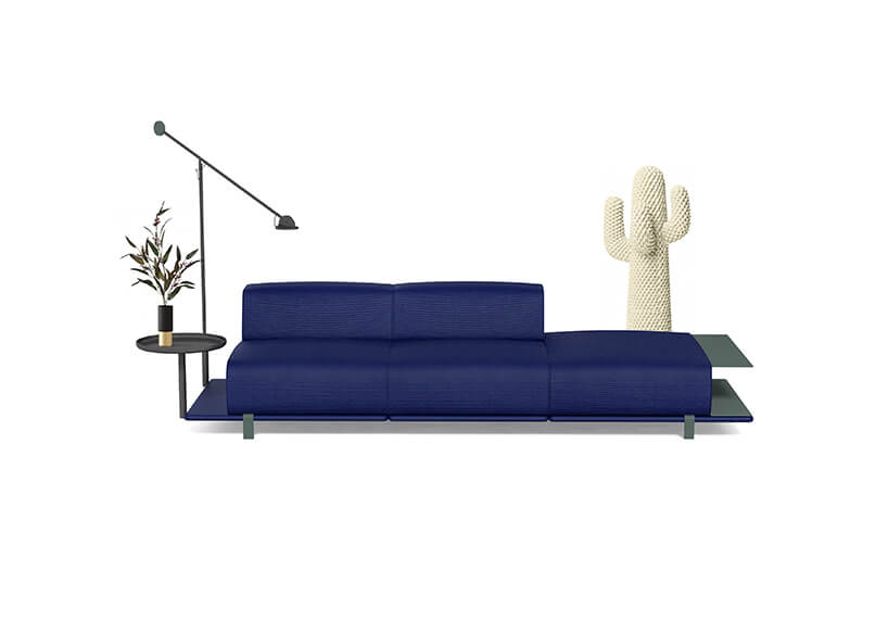 niebieska sofa z niskim oparciem ze stolikami po bokach i lampą od MK Design
