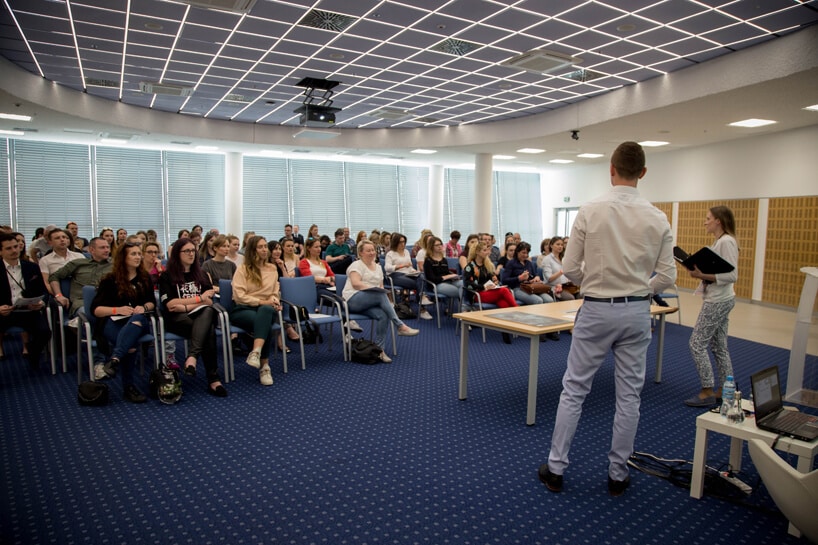 prowadzący warsztaty mężczyzna stojący na tle słuchaczy