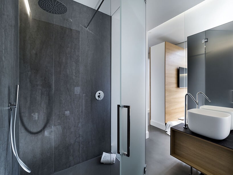 spieki kwarcowy Laminam w hotelu Habitat natrysk oddzielony szybą z ciemną ściana i podłogą