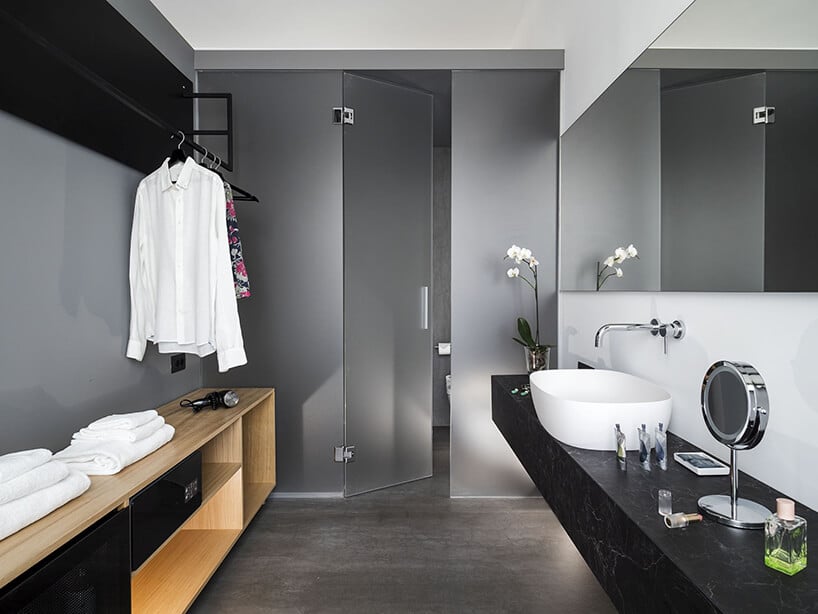 spieki kwarcowy Laminam w hotelu Habitat szara łązienka z czarnym kamiennym blatem