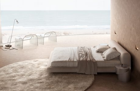 wyjątkowy pokój hotelowy duże beżowe łóżko na tle zaokrąglonego okna z widokiem na morze