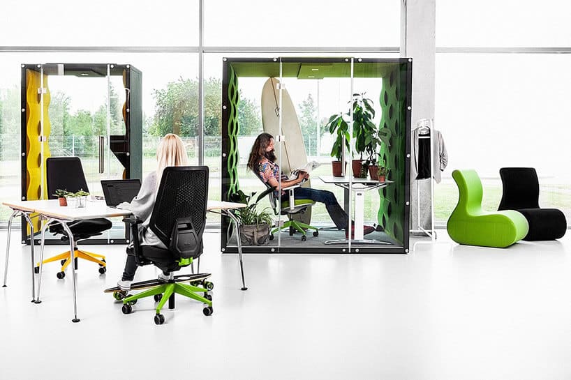 materiałowe boxy zamknięte szklanymi ściankami w białym open space