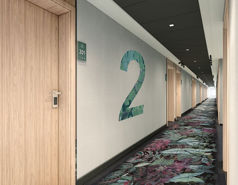 wnętrze hotelu ibis Styles Kraków od Accor hol z z jasnymi brązowymi drzwiami z wykładziną z motywem roślinnym