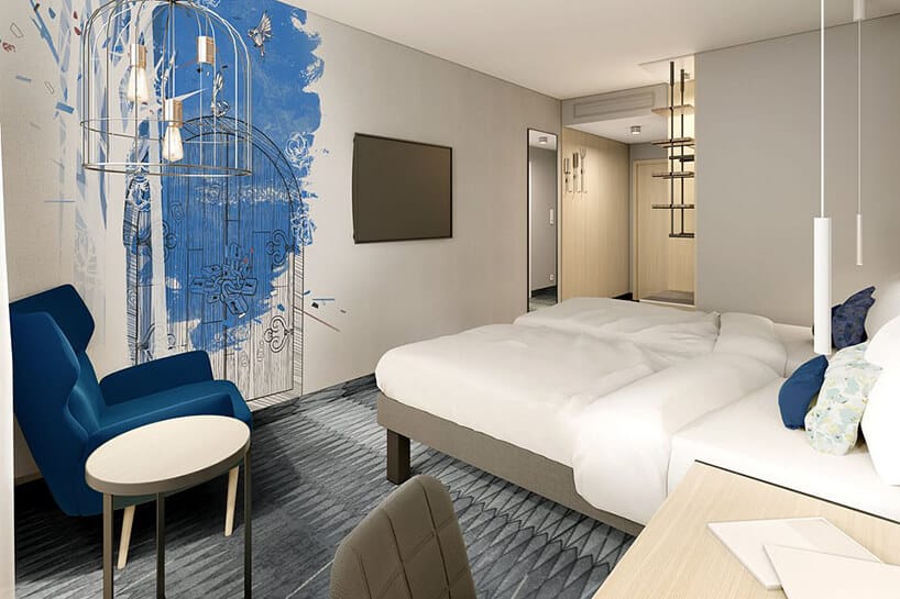 wnętrze hotelu ibis Styles Kraków od Accor jasne wnętrze pokoju z czarno niebieską grafika na ścianie z szarą wykładziną