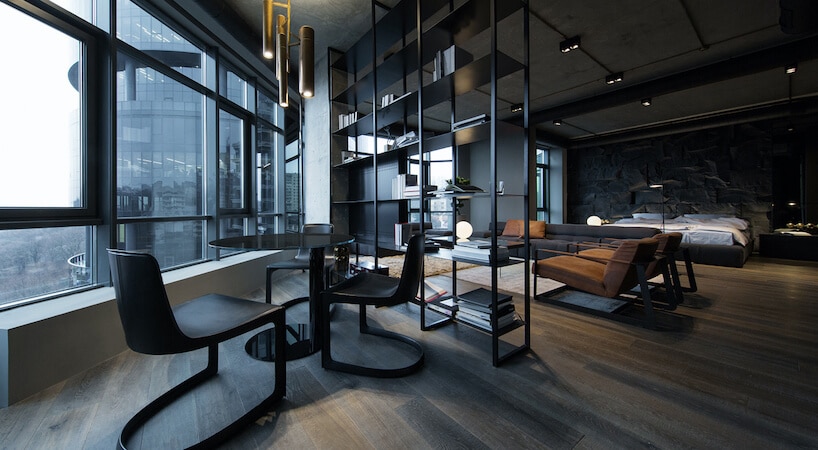 elegancki ciemny salon błyszczącym stołem z trzema czarnymi krzesłami na tle okien
