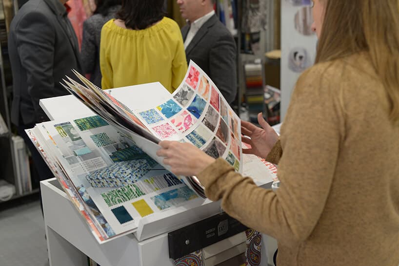 kobieta przeglądająca katalog próbek z materiałami obiciowymi