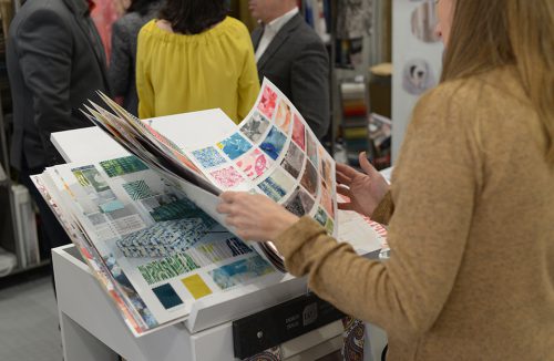 kobieta przeglądająca katalog próbek z materiałami obiciowymi