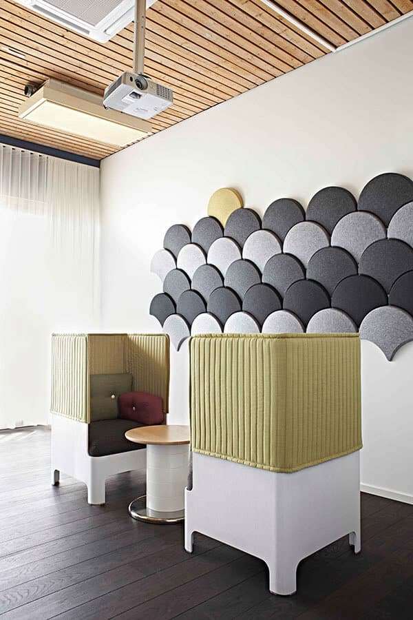 zabudowane fotele na tle ściany z filcowymi panelami