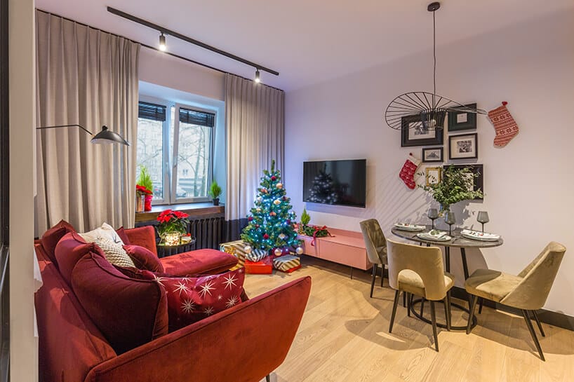 aranżacja jasnego salonu z drewnianą podłogą z czerwoną sofą od Decoroom