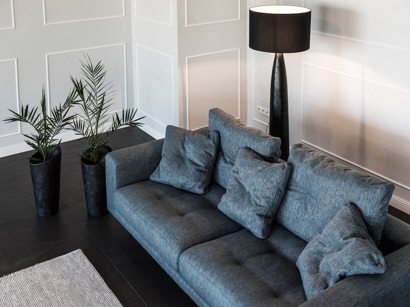 ciemno niebieska sofa na tle ciemnej podłogi