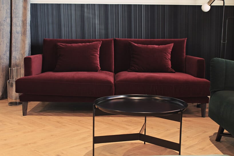bordowa sofa na drewnianej podłodze w ciemnym wnętrzu