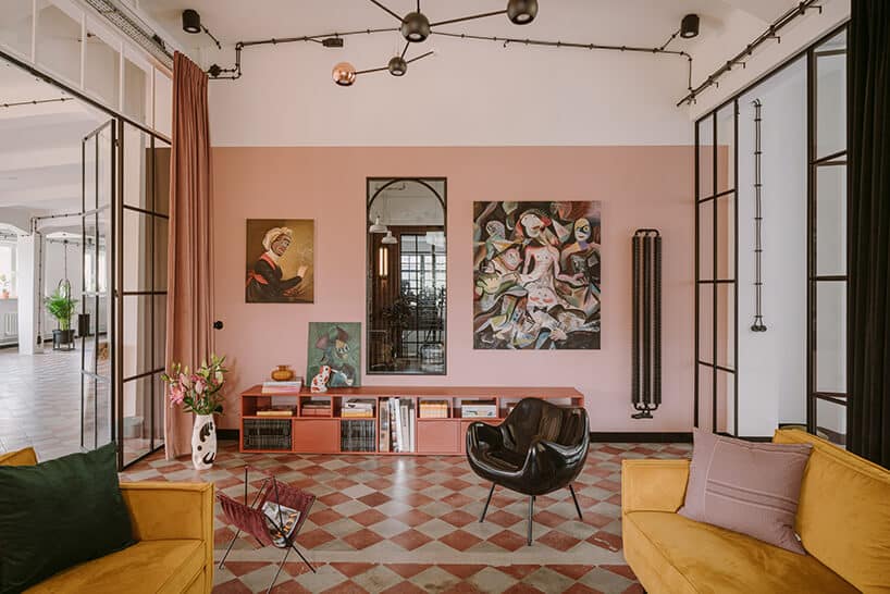 salon z dwoma żółtymi sofami i czarnym plastikowym fotelem w kreatywnym wnętrzu CLAY.WARSAW