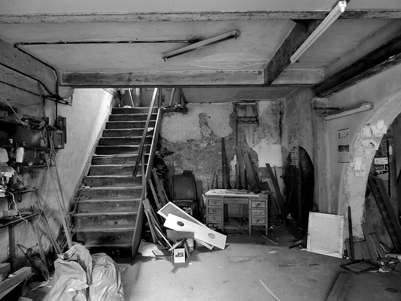 loft projektu KEMA studio obdrapane wnętrze z z drewnianymi schodami i duża liczbą starych rzeczy