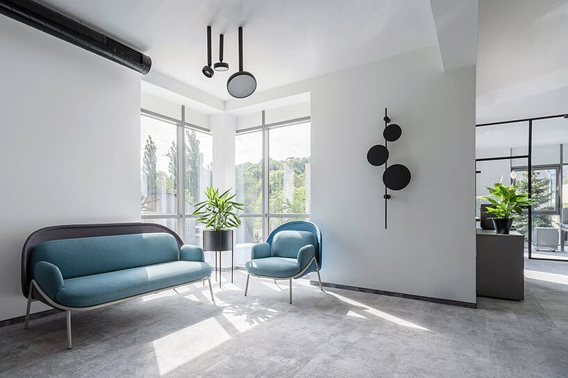 nowoczesna przestrzeń biurowa MDD Work Together niebieska sofa i fotel w białej przestrzeni z szarą podłogą