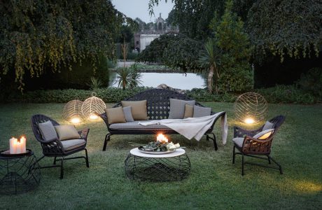 elegancki komplet mebli ogrodowych w ogrodzie wieczorem oświetlony świecami