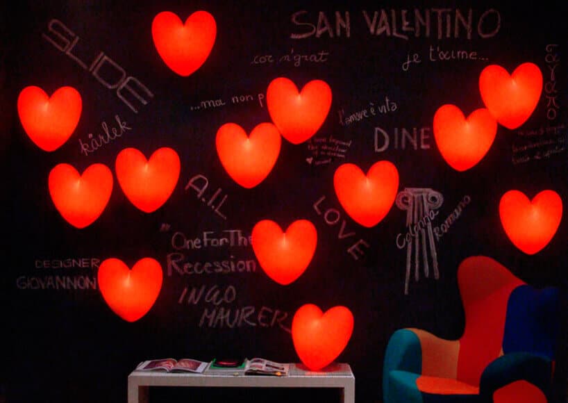 czarna ściana z napisami kredowymi i czerwonymi świecącymi sercami