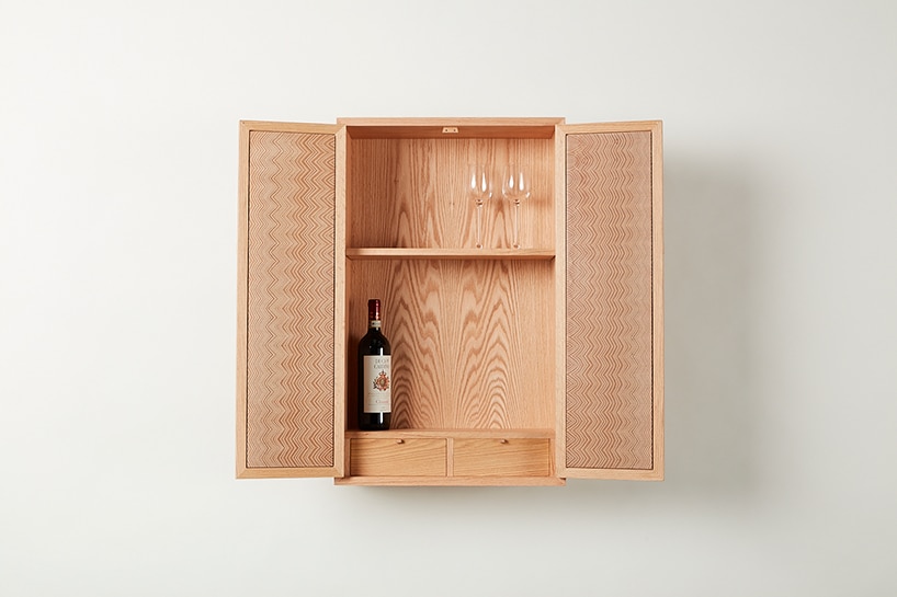 otwarta drewniana szafka na ścianie z winem w środku