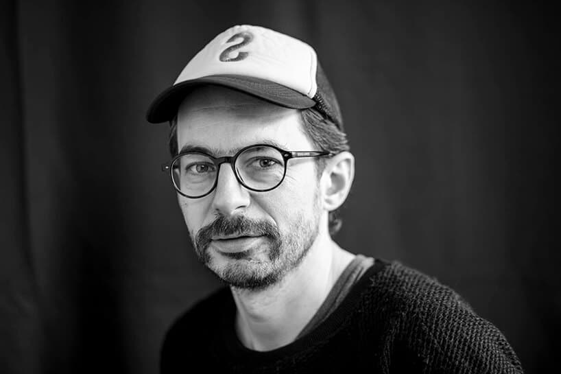 czarno białe zdjęcie projektanta wnętrz Szymona Hanczara w czapce z daszkiem