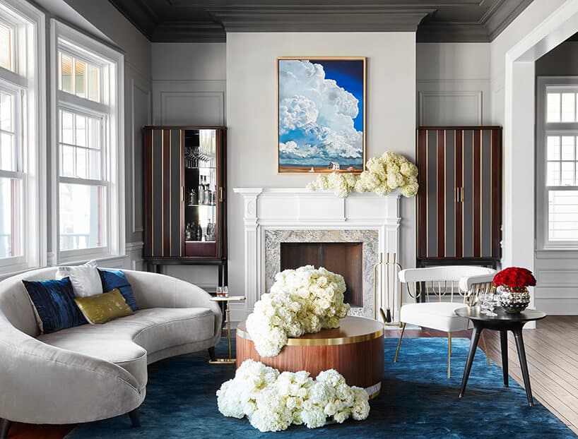 modernistyczne wnętrze Ravenswood Residence elegancki salon z ofwalną szarą sofą i dużym zdobionym kominkiem