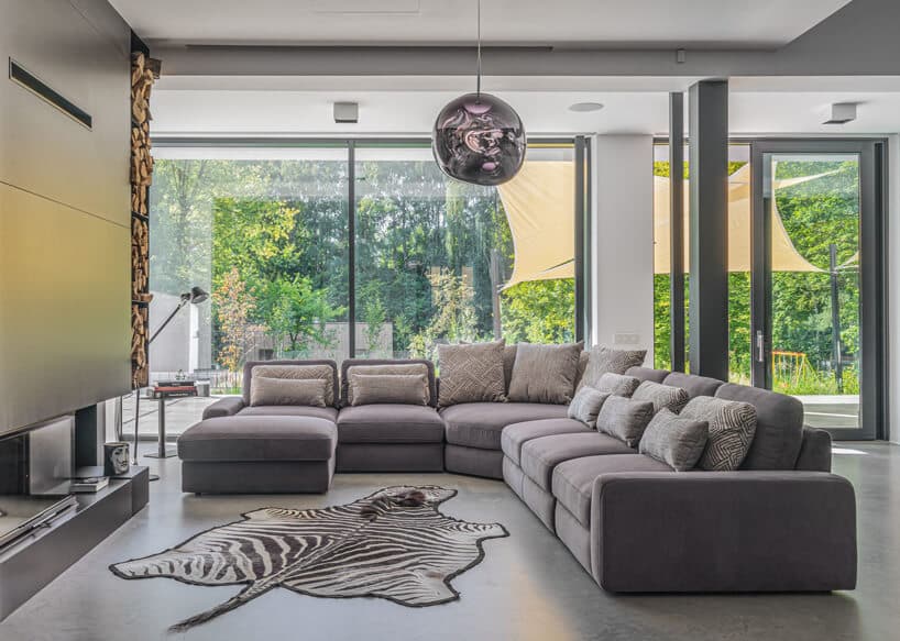 szara modułowa sofa Serena od Gala Collezione w przestronnym salonie obok skóry z białego tygrysa