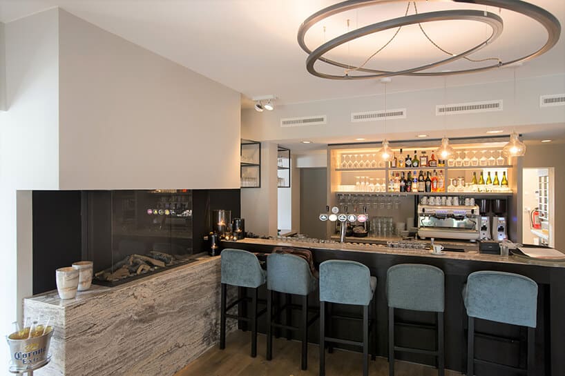 elegancki bar z ciemnym wykończeniem z pięcioma krzesłami obok kominka