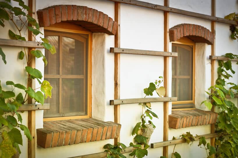 dwa okna w starym budynki z ceglanym parapetem i z moskitierami ANWIS