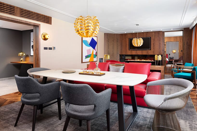 hotel Sofitel aranżacja apartamentu z wyjątkowym stołem z kamiennym blatem pod złotą lampą