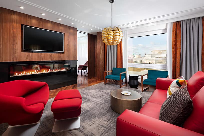 hotel Sofitel aranżacja apartamentu salonu z czerwoną sofą i fotelem