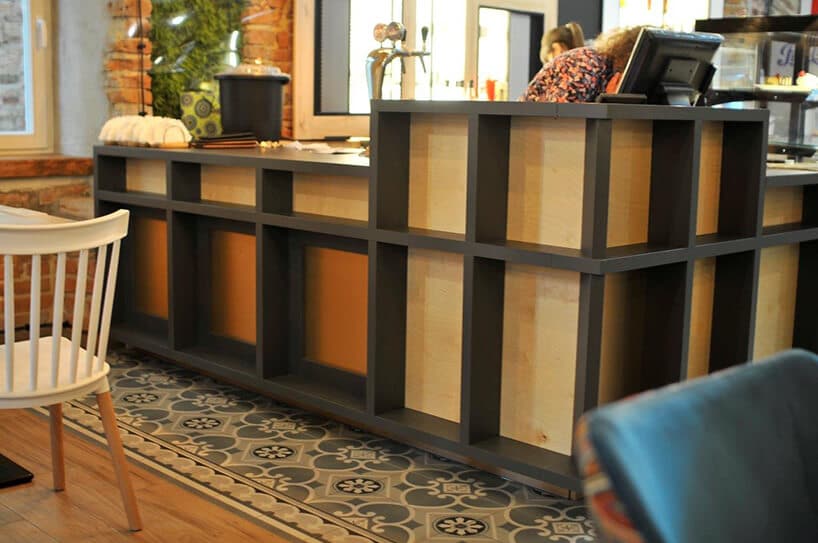 bar w restauracji zrobiony z desek oraz czarnej konstrukcji